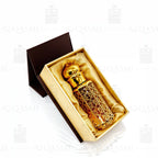Gold and amber glass bottle with intricate design on a white background. 12ML